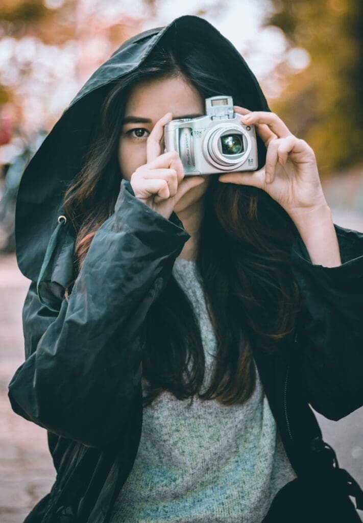 woman wearing jacket holding camera