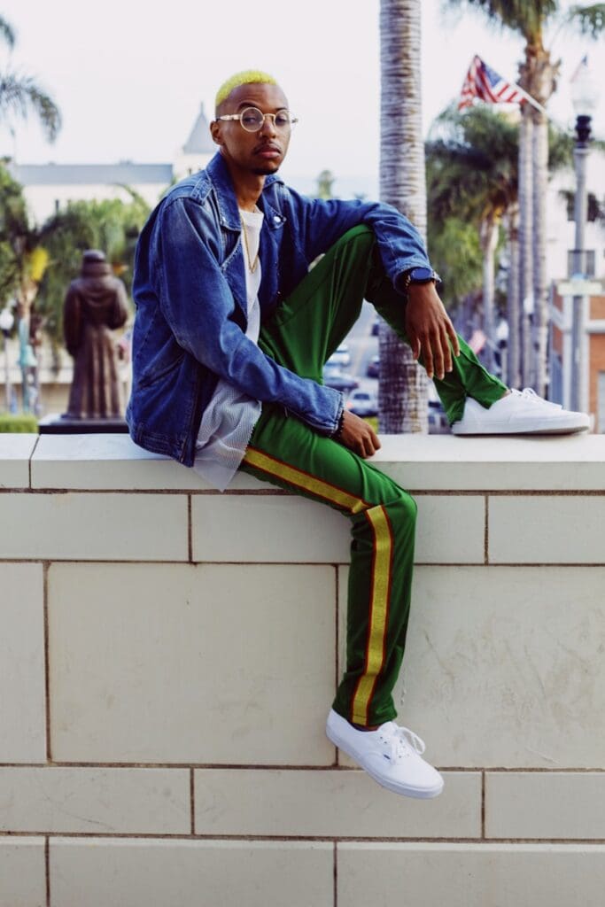 man sitting on top of white wall